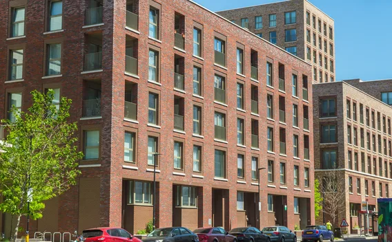 A new brick street frontage with balconies on the residential floors above ground-level units.